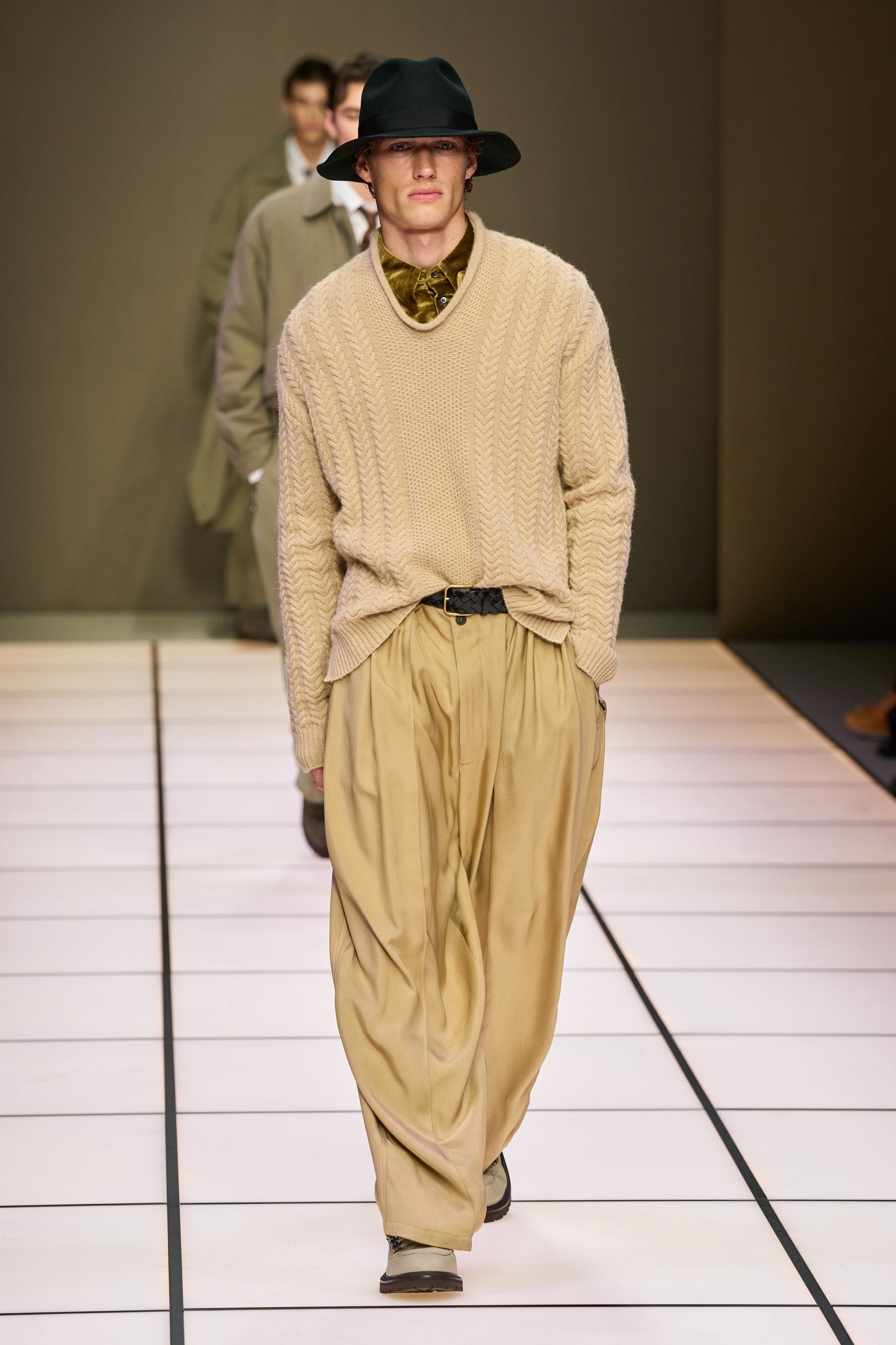Giorgio Armani 26FW 男装回归品牌最本质的语言：流动、克制与永恒。柔软大衣、宽松长裤、针织与轻结构西装在灰、驼、米与墨绿中缓慢展开，强调身体与面料之间的自然关系。系列几乎不依赖任何戏剧化装饰，却通过比例、步伐与质感建立权威感，是对“真正优雅无需证明”的再次确认，也是一种对快节奏时尚的温和抵抗-顽石频道趋势研究